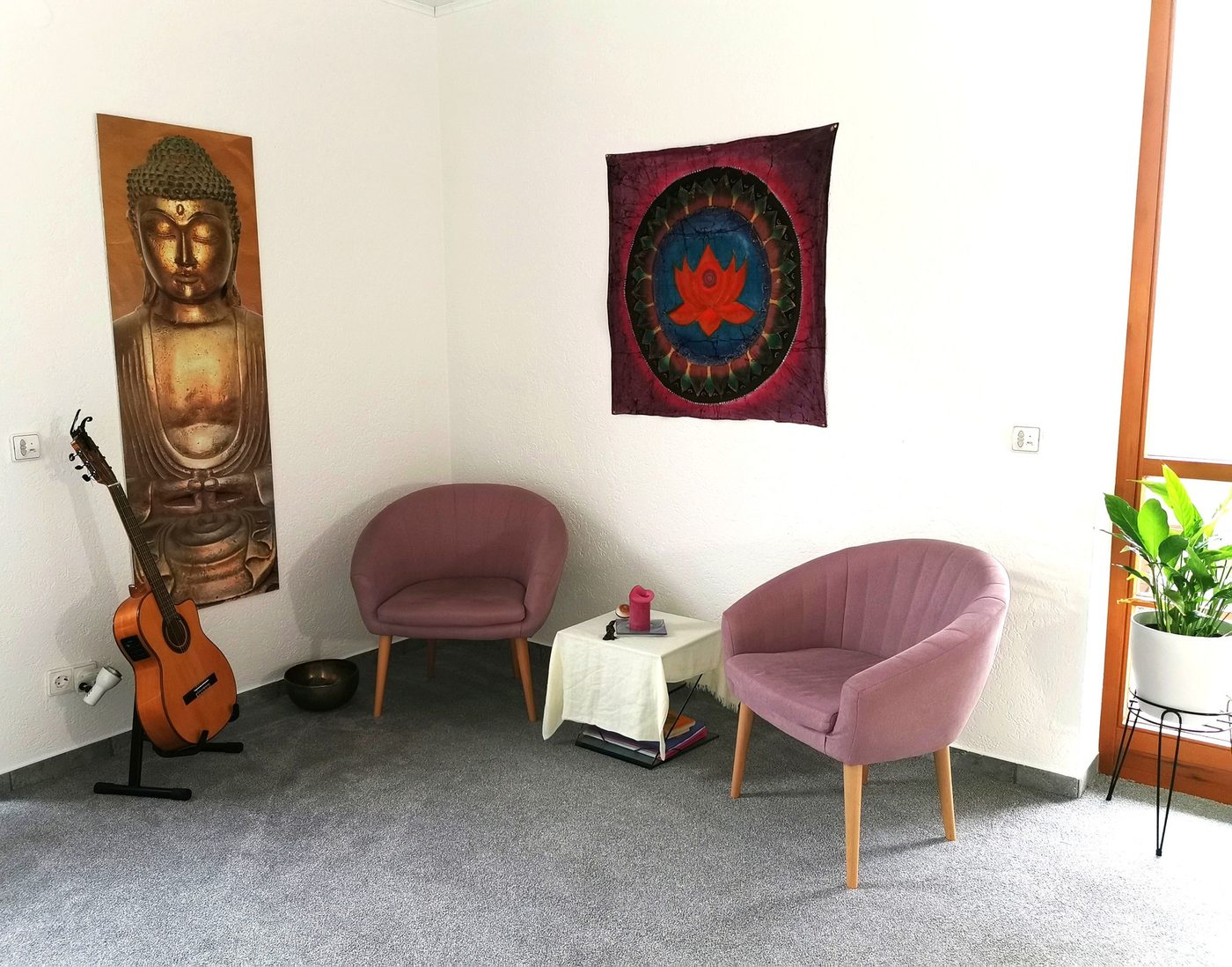 Der Satsangraum in Schielberg mit zwei Sesseln, Buddha-Bild und Gitarre
